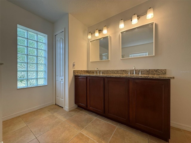 4920 E Lake Cove Blvd, Saint Cloud, FL 34771 - bathroom featuring double vanity, baseboards, and tile patterned floors