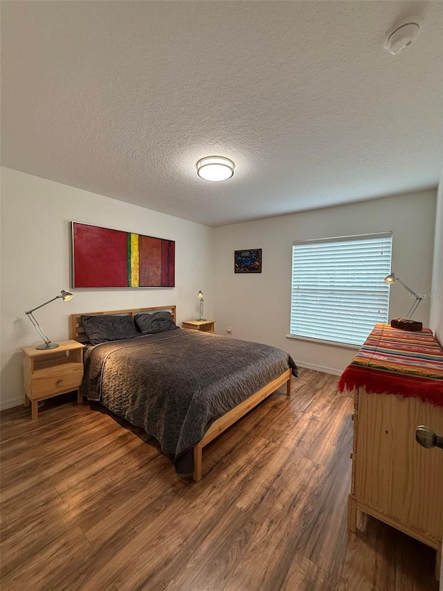 4920 E Lake Cove Blvd, Saint Cloud, FL 34771 - bedroom featuring wood finished floors, a textured ceiling, and baseboards