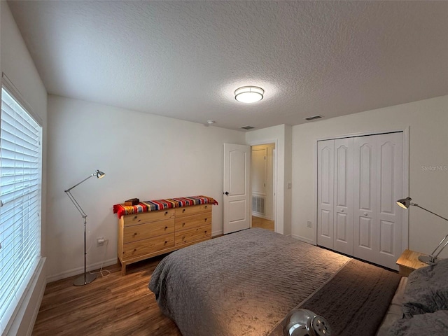 4920 E Lake Cove Blvd, Saint Cloud, FL 34771 - bedroom featuring baseboards, wood finished floors, a textured ceiling, and a closet