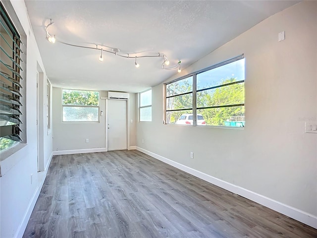 22131 Bahama Ave, Port Charlotte, FL 33952 - unfurnished room with baseboards, a wall unit AC, and wood finished floors