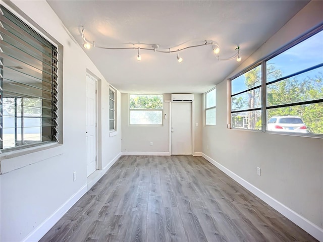 22131 Bahama Ave, Port Charlotte, FL 33952 - spare room featuring baseboards, a wall mounted air conditioner, and wood finished floors