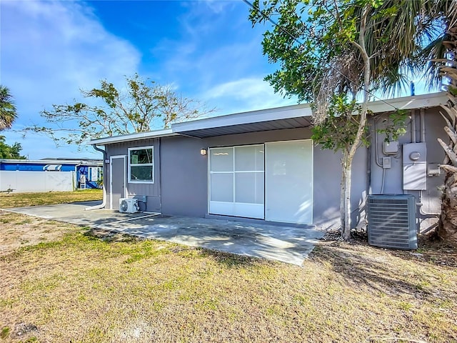 22131 Bahama Ave, Port Charlotte, FL 33952 - rear view of house featuring a lawn, central AC unit, stucco siding, and a patio