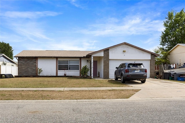 single story home featuring concrete driveway, brick siding, an attached garage, and a front yard