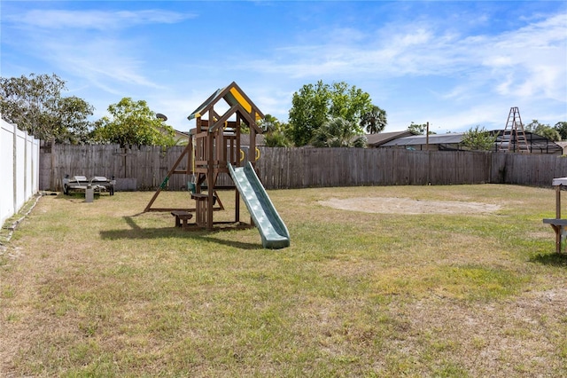 view of jungle gym featuring a lawn and a fenced backyard