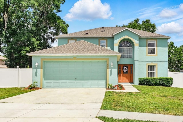 view of front facade featuring a garage, fence, a front lawn, concrete driveway, and stucco siding