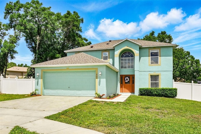 view of front facade with concrete driveway, fence, a front yard, and stucco siding