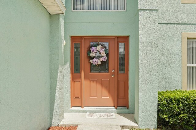 entrance to property featuring stucco siding