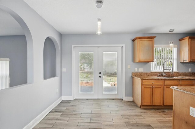 entryway with baseboards, french doors, wood finish floors, and a sink