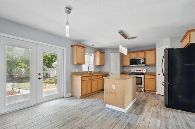 kitchen with french doors, visible vents, appliances with stainless steel finishes, a center island, and a sink