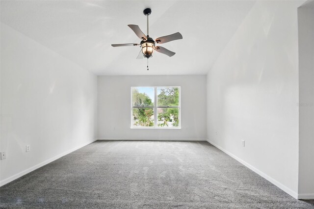 carpeted spare room featuring baseboards and ceiling fan