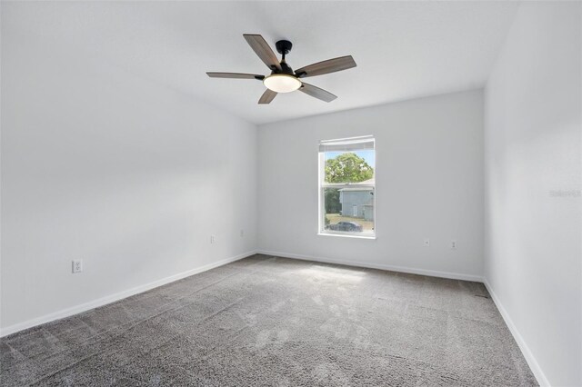 carpeted empty room featuring baseboards and a ceiling fan