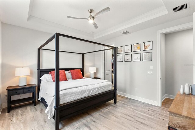 8848 Bismarck Palm Dr, Winter Garden, FL 34787 - bedroom featuring a tray ceiling, light wood finished floors, and visible vents