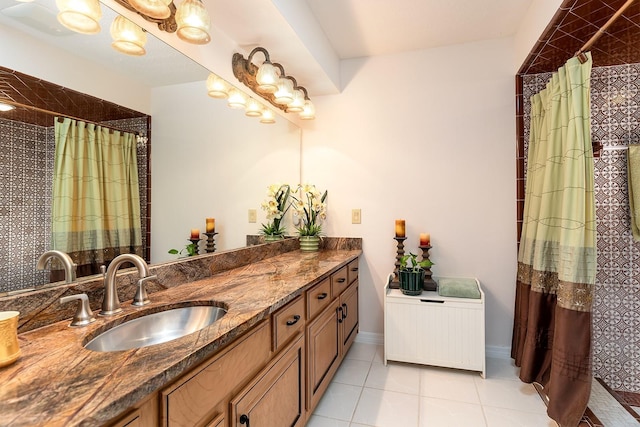 full bathroom featuring tile patterned flooring, baseboards, tiled shower, and vanity
