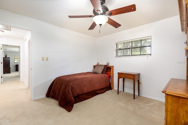 bedroom with baseboards, light carpet, visible vents, and a ceiling fan