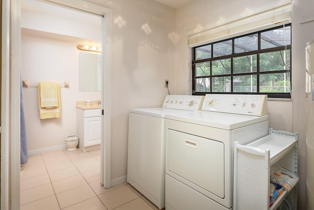 washroom featuring light tile patterned floors, laundry area, independent washer and dryer, and baseboards