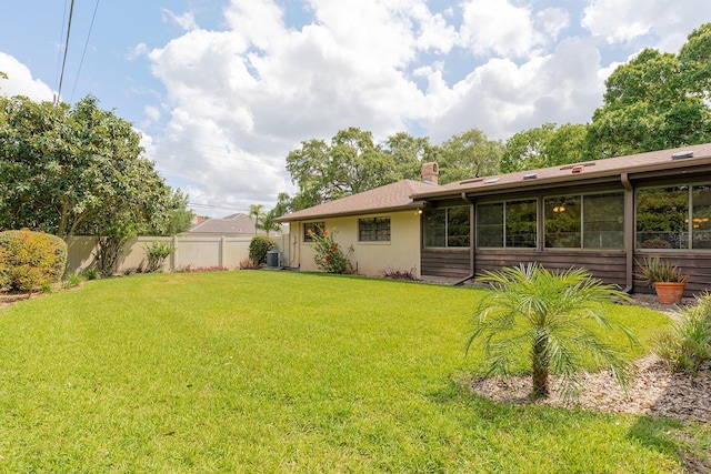 view of yard featuring central AC unit and fence