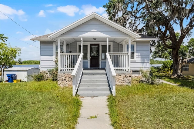 bungalow-style home with covered porch and a front yard