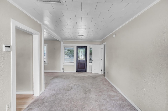 entrance foyer with baseboards, ornamental molding, carpet floors, and visible vents