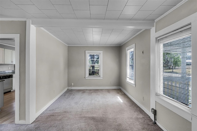 spare room with crown molding, baseboards, and light colored carpet