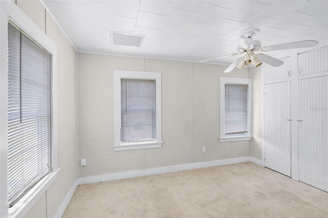 unfurnished bedroom featuring baseboards, ceiling fan, carpet, and visible vents