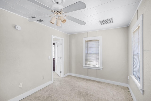 spare room with baseboards, carpet, a ceiling fan, and visible vents