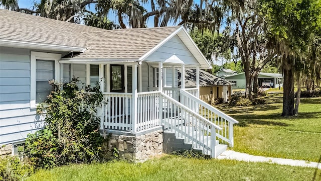 exterior space with a yard and a shingled roof