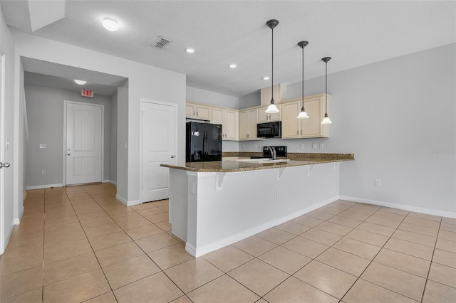 5118 Adelaide Dr, Kissimmee, FL 34746 - kitchen with a peninsula, a kitchen breakfast bar, black appliances, visible vents, and light tile patterned floors