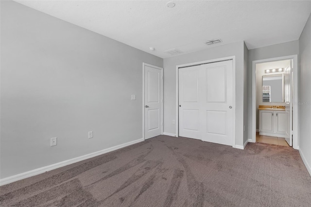 5118 Adelaide Dr, Kissimmee, FL 34746 - unfurnished bedroom featuring a closet, baseboards, carpet flooring, visible vents, and connected bathroom