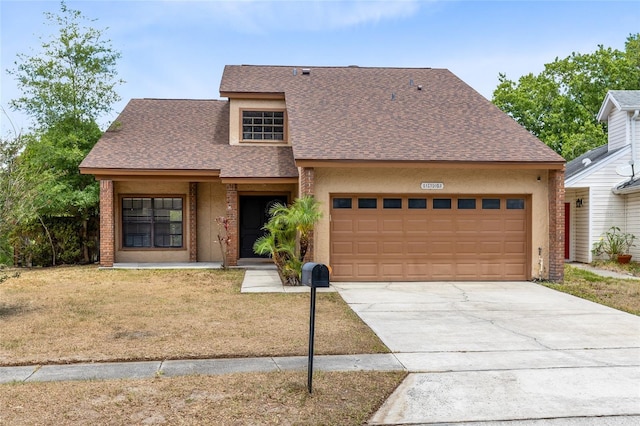 view of front of home featuring a front lawn, stucco siding, a shingled roof, an attached garage, and driveway