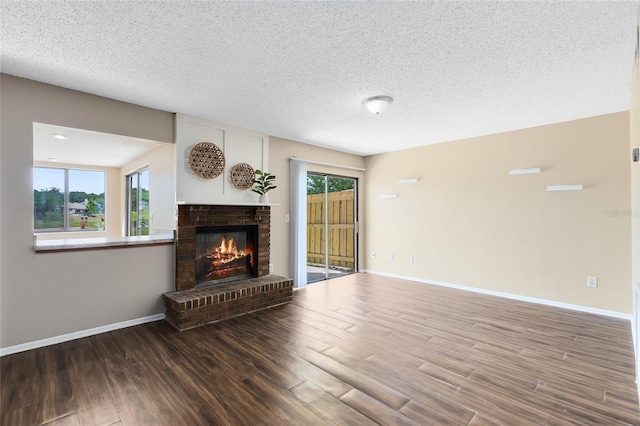 unfurnished living room featuring a textured ceiling, baseboards, wood finished floors, and a fireplace