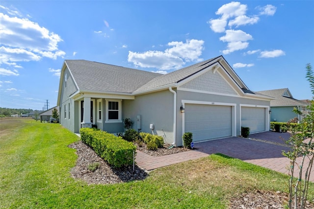 single story home with a front yard, stucco siding, a shingled roof, an attached garage, and driveway