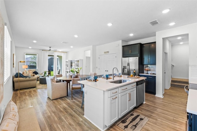 kitchen with visible vents, appliances with stainless steel finishes, a sink, light countertops, and light wood-style floors
