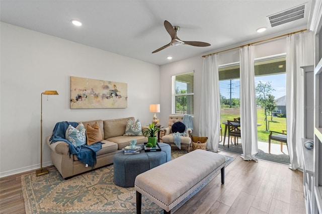 living room featuring visible vents, baseboards, recessed lighting, light wood-type flooring, and a ceiling fan