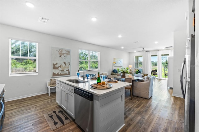 kitchen featuring visible vents, appliances with stainless steel finishes, dark wood finished floors, a sink, and light countertops