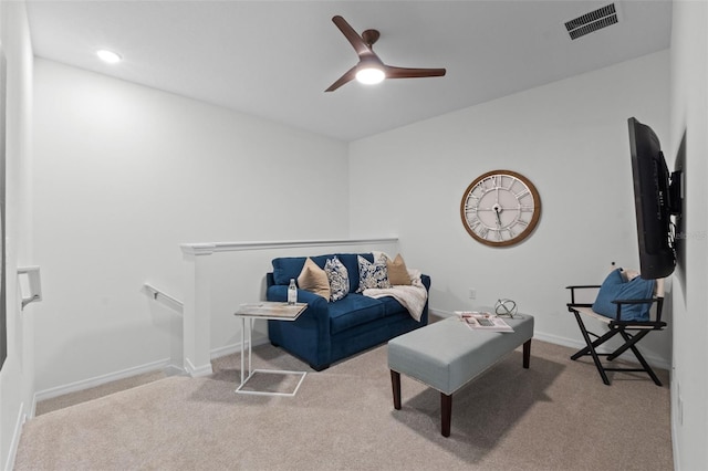 living room featuring carpet floors, baseboards, ceiling fan, and visible vents