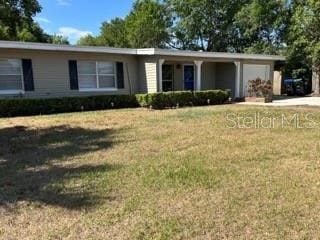 single story home featuring an attached garage and a front lawn