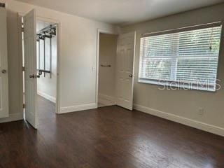 unfurnished room featuring baseboards and wood finished floors