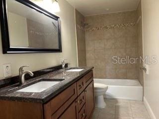 full bathroom with toilet, baseboards, a sink, and tile patterned flooring