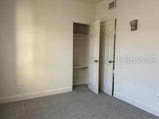 unfurnished bedroom featuring a closet, baseboards, and carpet flooring