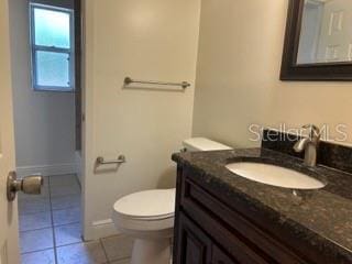 full bath featuring vanity, tile patterned floors, and toilet