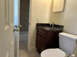 bathroom with toilet, baseboards, tile patterned flooring, and vanity