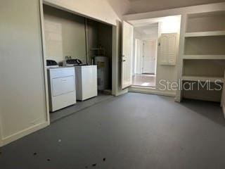 interior space featuring concrete floors, gas water heater, and washer and dryer