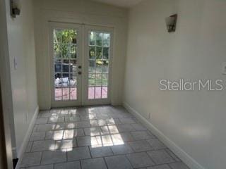 interior space with baseboards and french doors