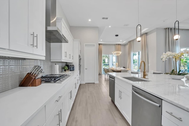 7905 Jacks Club Dr, Kissimmee, FL 34747 - kitchen featuring stainless steel appliances, wall chimney exhaust hood, a sink, decorative backsplash, and white cabinets