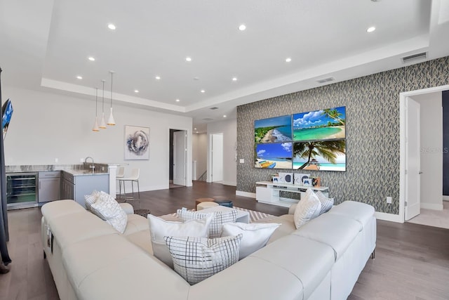 7905 Jacks Club Dr, Kissimmee, FL 34747 - living room with a tray ceiling, wood finished floors, beverage cooler, wallpapered walls, and baseboards
