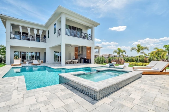 7905 Jacks Club Dr, Kissimmee, FL 34747 - back of house featuring a balcony, a patio, outdoor lounge area, stucco siding, and a pool with connected hot tub