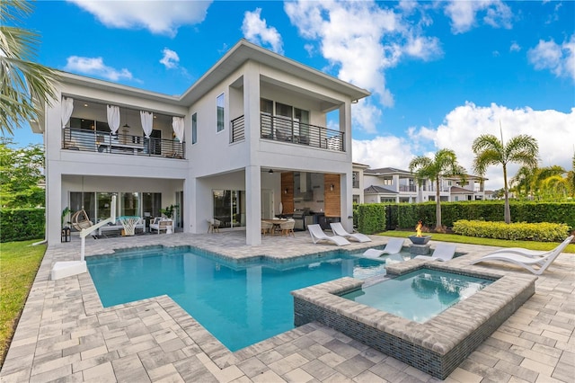 7905 Jacks Club Dr, Kissimmee, FL 34747 - back of property featuring a balcony, an outdoor hangout area, a patio area, stucco siding, and a pool with connected hot tub