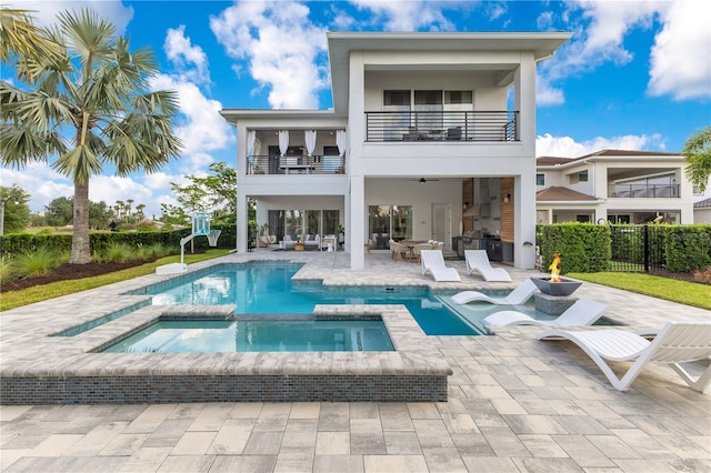 7905 Jacks Club Dr, Kissimmee, FL 34747 - back of property featuring a balcony, a patio area, stucco siding, a pool with connected hot tub, and fence