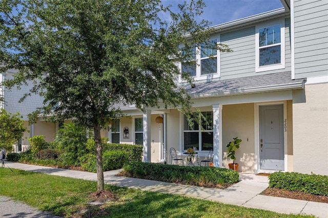view of property featuring covered porch and stucco siding