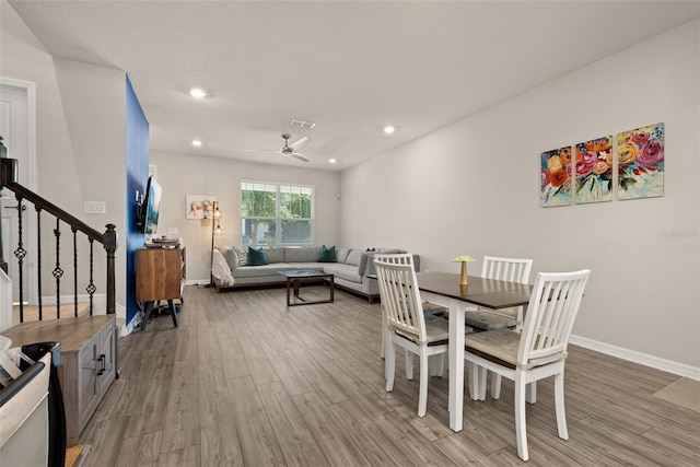 dining space featuring light wood-style flooring, baseboards, ceiling fan, recessed lighting, and stairway